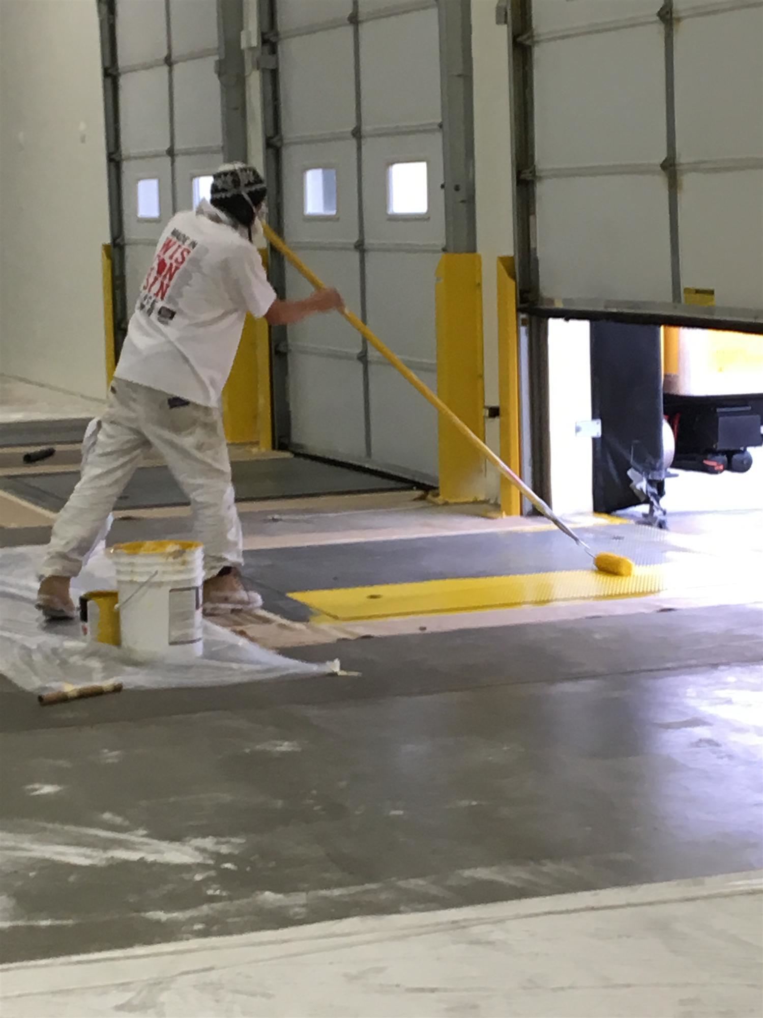 K2 painting contractor hard at work painting a loading dock safety yellow